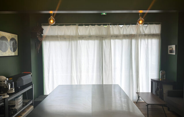 壁:FARROW&BALL No.310 Beverly / PARQUE TOKYOファクトリーの大きな出入り口から差し込む彩光と室内を照らす暖かな照明。光の具合で壁や天井の色が繊細に変化していくのは、Farrow&Ballならではの特徴です。