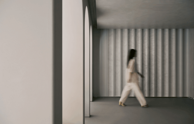 銀座にあるショールーム「 Layered Gallery by Valpaint」。イタリア最高峰のVALPAINT（バルペイント）を中心に、意匠性の高い水性塗料がたくさん揃っており、インテリアデザインのインスピレーションを高めてくれるショールームとなっています。ご来店は、完全予約制です。そのステップをご紹介します。写真は、VALPAINTで塗装されたLayered Galleryを女性が歩いている様子。