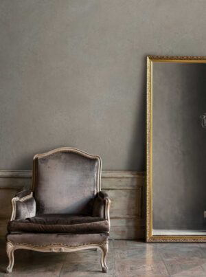 （壁）VALPAINT：Valrenna / 豊富なカラーと耐久性を兼ね備えた スエードのバックスキンのような非常に柔らかな感触のVALRENNA。その触感もソフトで、空間に淑やかさをもたらします。写真の壁はウォームなグレイッシュカラー。上品なチェアと鏡を引き立てるナチュラルかつシックな印象を演出しています。