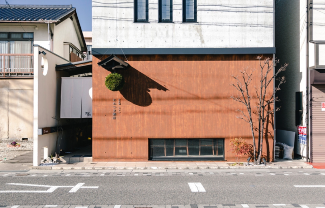 長野県のおおつき酒店。外壁に塗装されたKlondike CORTEN -クロンダイクコルテン-。RC造の無機質な冷たさと、コールテン鋼の有機的で力強い温かみ。そこに杉玉の緑と暖簾の白が加わり、和モダンの完成度を高めています。本物の鉄板では避けられない「サビ汁による汚れ」のリスクも、塗料だからこそゼロに。